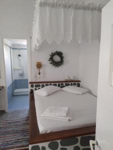 a white bedroom with a bed with a window at Mandrakia house in Mandrakia