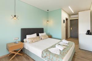 Un dormitorio con una cama y una mesa con toallas. en Regos Resort Hotel, en Neos Marmaras