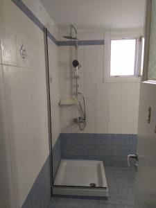een badkamer met een douche en een bad bij Mandrakia house in Mandrakia