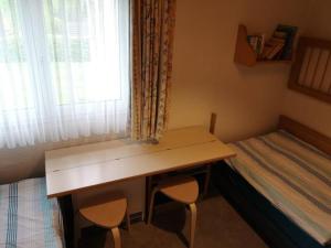 Schlafzimmer mit einem Schreibtisch und einem Bett mit einem Fenster in der Unterkunft Maja am See in Biersdorf
