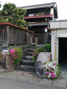 una casa con flores delante en ゲストハウス山本 en Gifu