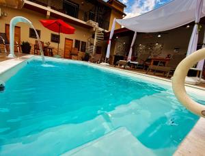 una piscina de agua azul frente a una casa en Guest House Della Vita, en Ilhabela