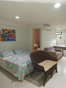 - une chambre avec un lit, une chaise et un lavabo dans l'établissement Flat Nord Tabatinga, à Conde