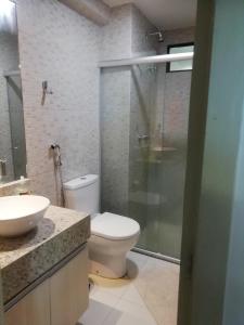 La salle de bains est pourvue de toilettes et d'une douche en verre. dans l'établissement Flat Nord Tabatinga, à Conde