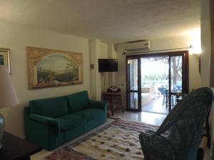 a living room with a green couch and a sliding glass door at Punta Lada in Porto Rotondo