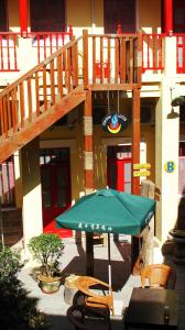 un parasol vert et des chaises sous un escalier dans l'établissement Wheat Youth Hostel Qingdao, à Qingdao