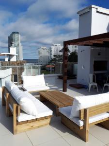 um pátio com sofás e mesas no telhado em Estudio con parrillero y vista al mar em Punta del Este
