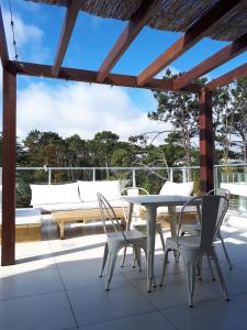 un patio con mesa y sillas en una terraza en Estudio con parrillero y vista al mar, en Punta del Este