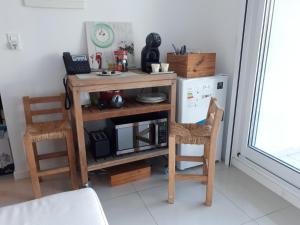 埃斯特角城的住宿－Estudio con parrillero y vista al mar，厨房配有木桌和两把椅子