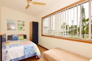 - une chambre avec un lit et une grande fenêtre dans l'établissement LAKE146C - Casa Iolanda, à Culburra Beach