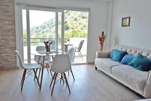 ein Wohnzimmer mit einer Couch und einem Tisch und Stühlen in der Unterkunft Verano ETERNO en Mallorca - Alcudia! in Alcúdia