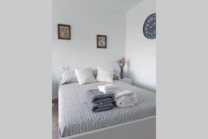 ein weißes Schlafzimmer mit einem Bett mit Handtüchern darauf in der Unterkunft Verano ETERNO en Mallorca - Alcudia! in Alcúdia