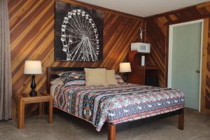 1 dormitorio con 1 cama y una noria en la pared en Kern Riverview Inn en Kernville