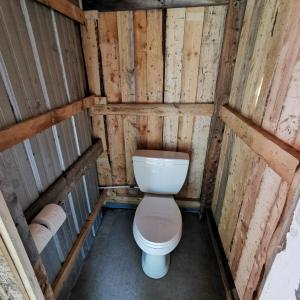 a bathroom with a toilet in a wooden structure at Blue Bayou Resort, Cape Breton in Dingwall +52 photos