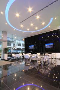 um restaurante com mesas e cadeiras brancas num edifício em Arton Boutique Hotel em Singapura