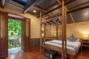 a bedroom with a four poster bed and a window at Yangshuo Secret Garden in Yangshuo