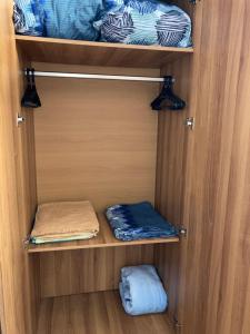 a wooden cupboard with two folded towels in it at Comfortable apartment in Vladivostok in Vladivostok