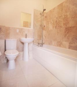 a bathroom with a toilet and a sink and a tub at Lantana Resort Barbados by Island Villas in Saint James