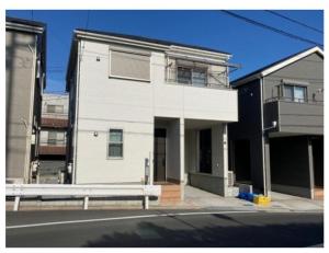un bâtiment blanc sur le côté d'une rue dans l'établissement Bessalov Home 2nd room friendly house, à Tokyo