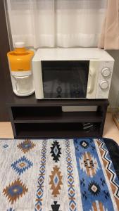 eine Mikrowelle auf einem Tisch mit einem Teppich in der Unterkunft Bessalov Home 2nd room friendly house in Tokio