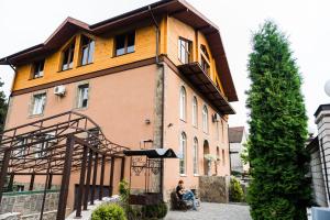 a person sitting in a wheelchair in front of a house at Golden park Apartments in Umanʼ