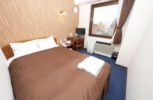 um quarto de hotel com uma cama e uma janela em Famy Inn Makuhari em Chiba