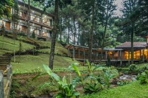 a house in the woods with a garden in front of it at Griya Dunamis by SABDA in Puncak