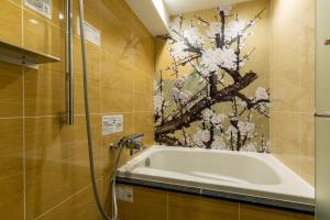 a bath tub in a bathroom with a painting on the wall at ホテルカルタ赤坂 in Tokyo