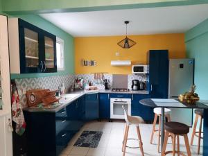 eine blau-gelbe Küche mit einem Tisch und Stühlen in der Unterkunft Villa Casa Ti Choul in Rivière-Pilote