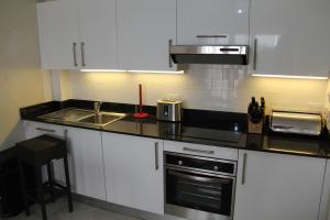 a kitchen with white cabinets and a sink at Lantana Resort Barbados by Island Villas in Saint James
