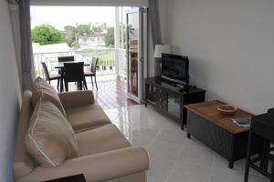a living room with a couch and a television at Lantana Resort Barbados by Island Villas in Saint James