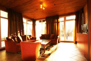 a living room with couches and a table and windows at Vila Elena in Palanga