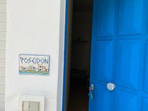 een blauwe deur met een bord op een muur bij Case Vacanze Ganimede in Sperlonga
