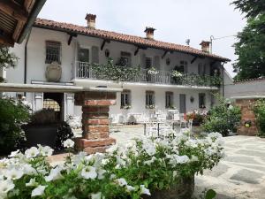 een groot wit huis met een patio met witte bloemen bij ANTICA VILLA - Guest House & Hammam - Servizi come un Hotel a Cuneo in Cuneo
