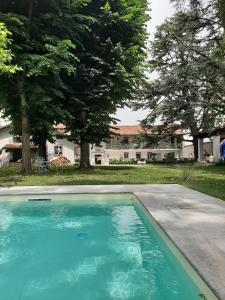 una piscina frente a una casa con árboles en ANTICA VILLA - Guest House & Hammam - Servizi come un Hotel a Cuneo en Cuneo