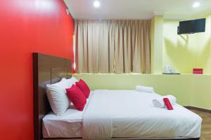 a bedroom with a bed with red and white pillows at Hotel Sunjoy9 Bandar Sunway in Petaling Jaya