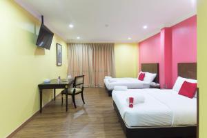 a hotel room with two beds and a desk at Hotel Sunjoy9 Bandar Sunway in Petaling Jaya