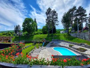 un jardín con flores y una piscina en Plitvice Ethno House, en Jezerce