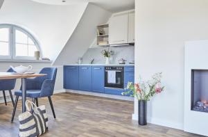 a kitchen with blue cabinets and a table at ReetTraum Prerow in Prerow