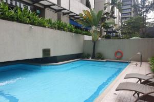 a large blue swimming pool next to a building at Studio at Olympia Makati GREAT Location, Vaccination Card Required in Manila