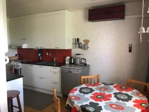 cocina con mesa y mantel con flores en Apartment with aircondition and sauna en Kuusamo