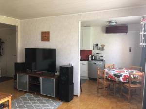 un soggiorno con TV e tavolo e una cucina di Apartment with aircondition and sauna a Kuusamo