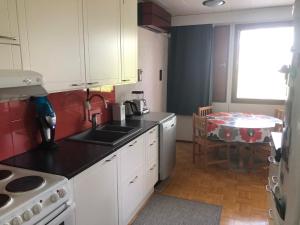 a kitchen with a sink and a table in it at Apartment with aircondition and sauna in Kuusamo