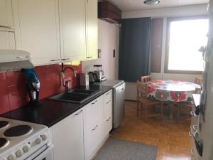 una cucina con lavandino e tavolo di Apartment with aircondition and sauna a Kuusamo Altre 7 foto