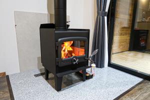 a black stove with a fire in a room at B&B MIKAWA 5 - Villas with BBQ Terrace in Kanazawa