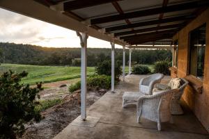 a patio with chairs and a view of a field at Glen Mervyn Lodge in Mummballup