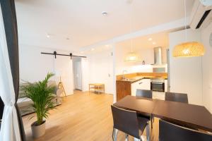 cocina y sala de estar con mesa y sillas en Apartaments Voralmar, en Caldes d'Estrac