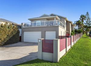 een huis met een hek en een garage bij Shellharbour Seaside Escape in Shellharbour