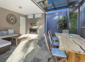 een woonkamer met een houten tafel en stoelen bij Shellharbour Seaside Escape in Shellharbour