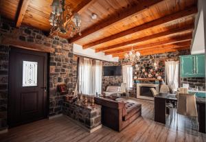 a living room with wooden ceilings and a stone wall at Villa Avia in Milatos